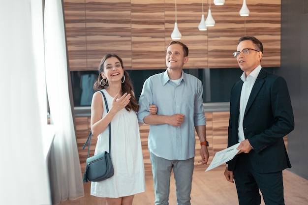 Stylish young wife smiling choosing house with husband