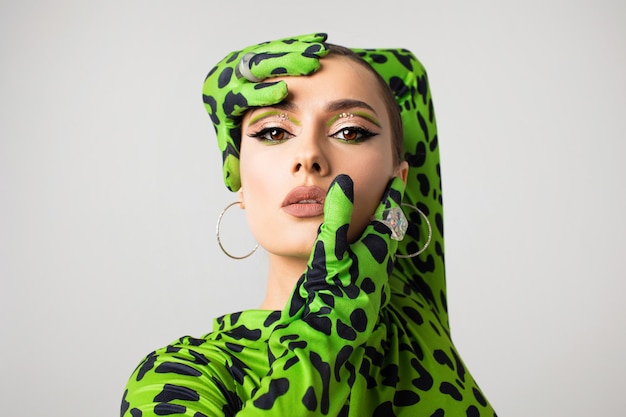 Foto giovane donna alla moda in un primo piano del ritratto dello studio della tuta del leopardo verde