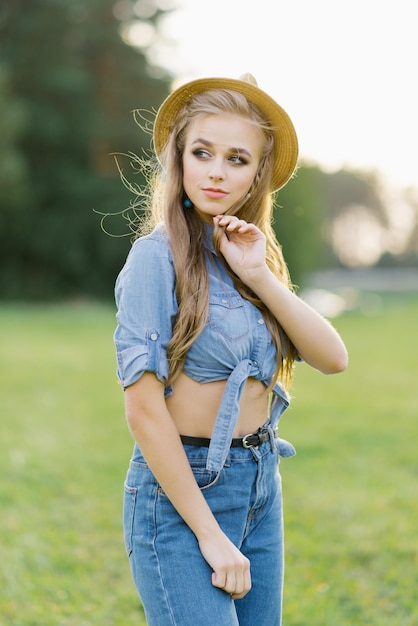 Photo stylish young woman in a hat walks outdoors in summer