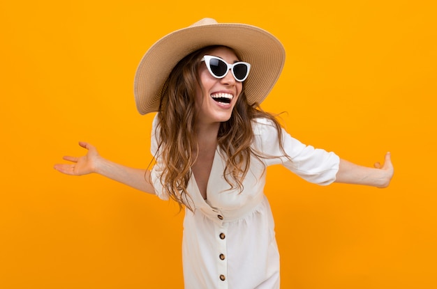 Stylish young woman in a hat on a yellow 