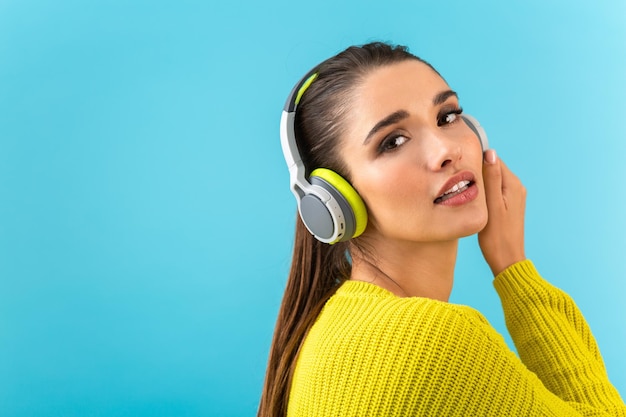 Stylish young woman holding listening to music in headphones