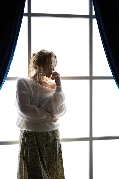 Stylish young woman in modern interior in the contrasting light