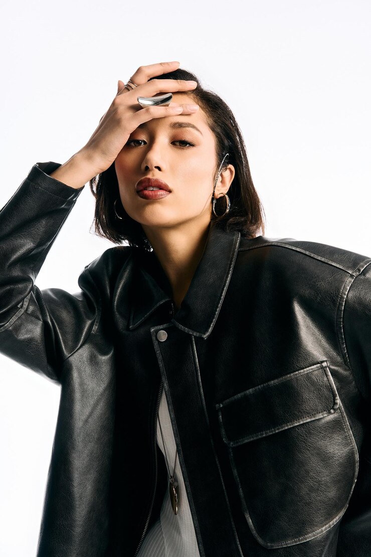 Photo 印象的な黒い革のジャケットを着てモダンなファッションを披露しているスタイリッシュな若い女性