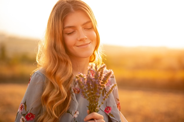 Stylish young woman standing in field