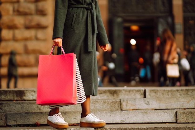 Stylish young woman in trendy clothes with shopping bags after shopping Autumn shopping