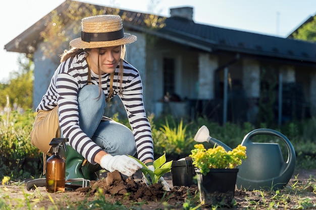 Фото Стильная молодая женщина-садовник сажает растение в саду