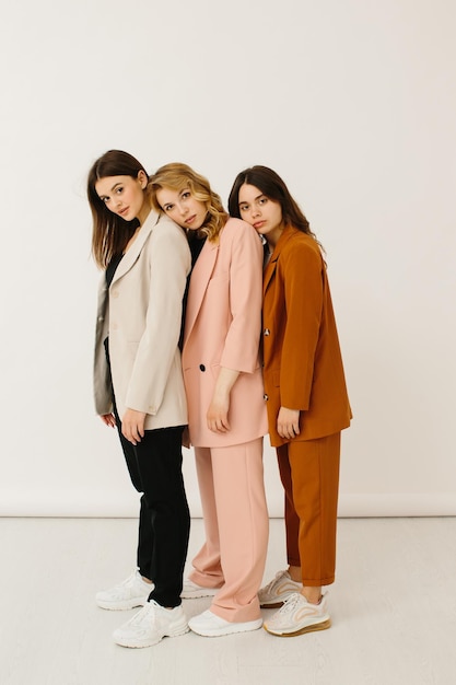 Stylish young women in pastel outfits standing together fashion concept stock photo