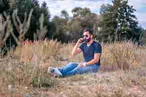 Photo stylishvape man in the fresh air smoking an electronic smoke device. handsome man.