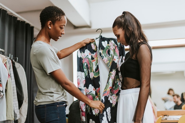 Stilista che sceglie un vestito per la modella