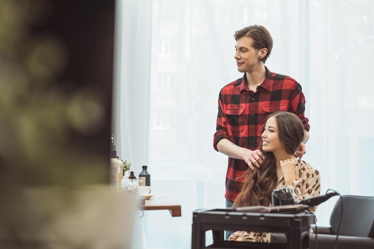 Stylist kapper styling lang haar voor mooie Aziatische jonge vrouw in de schoonheidssalon werkmoment