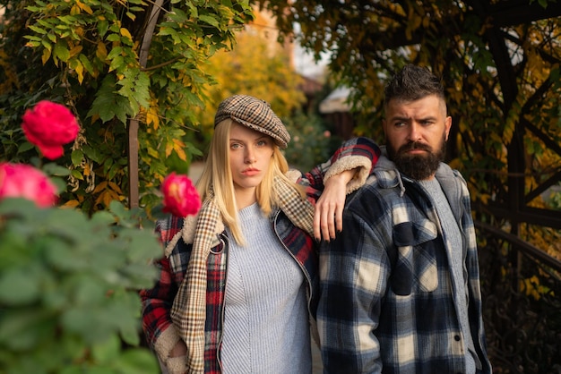 Stylist service. Lumberjack style. Couple wear checkered clothes nature background. Man bearded hipster and girl wear kepi hat. Checkered style. Couple handsome bearded hipster and fashion girl