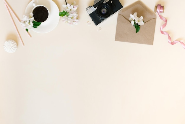 사진 양식화된 여성용 책상 사무실 책상 카메라가 있는 직장 흰색 꽃이 있는 봉투