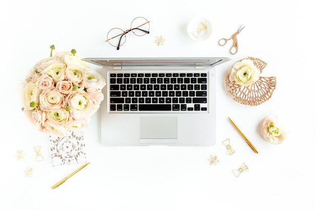 Photo stylized womens home office desk workspace with laptop computer bouquet ranunculus and roses clipboard on white background flat lay top view