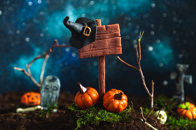 Stylized wooden signpost cemetery and pumpkins against the background of the starry sky