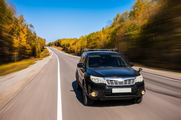 Foto subaru forester rijdt in de herfst op de weg