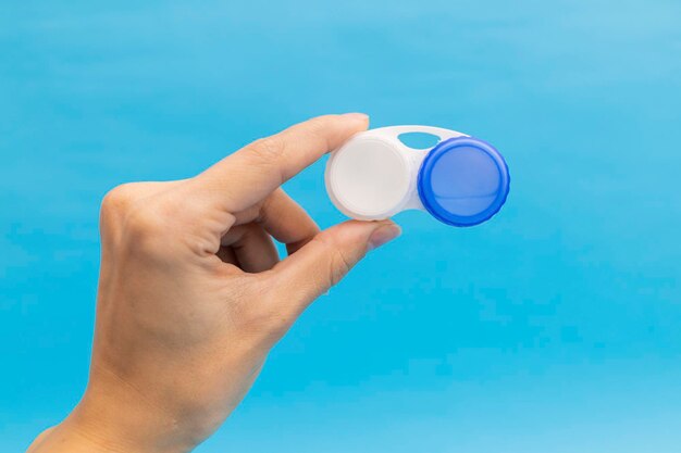 Предметная фотосъемка контактных линз на синем фоне с жидкостью для линз