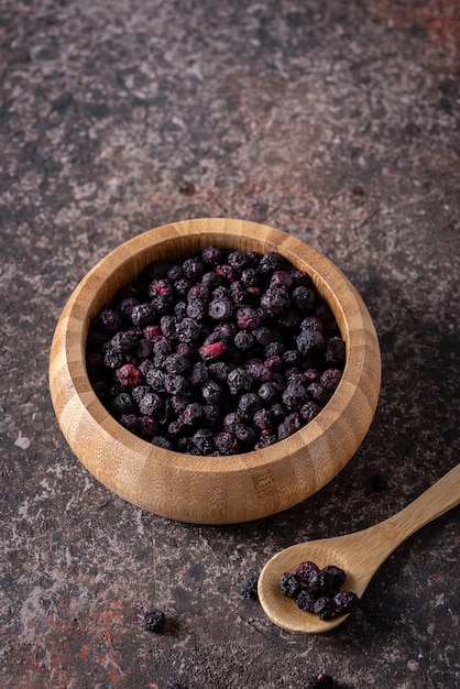 Sublimated blueberries in a brown ceramic plate on a dark background