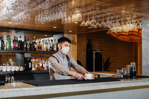 Submission of a Barista in a mask of delicious organic coffee in modern cafe during the pandemic