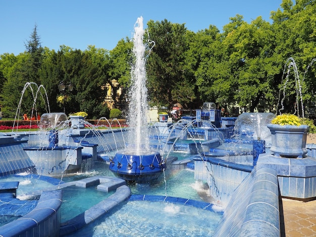 Subotica Servië 12 september 2021 Blauwe fontein op het plein naast het stadhuis Blauwe keramische onderdelen met monogrammen Een werkende fontein met opspattend water Zonnige zomerdag aan het blauwe water