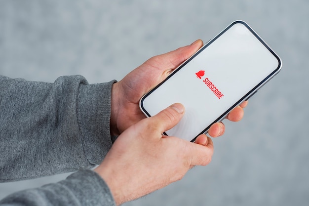subscribe to the internet channel on the smartphone display. man holds smartphone close-up with icon.