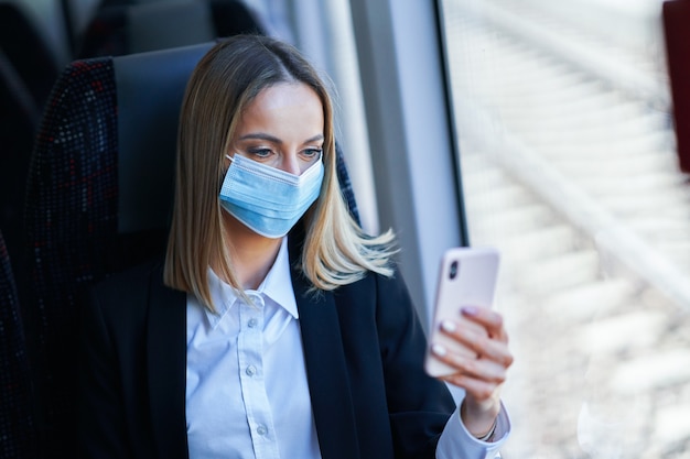 Subway forens zakenvrouw in masker op openbaar vervoer met smartphone