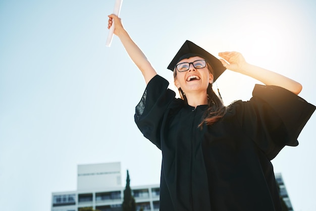 Succes afstuderen en vrouw of student met certificaat of diploma lage hoek Afgestudeerde viering en vrouwelijke geleerde blij met academische prestatie universitaire doelen of onderwijsdoelen