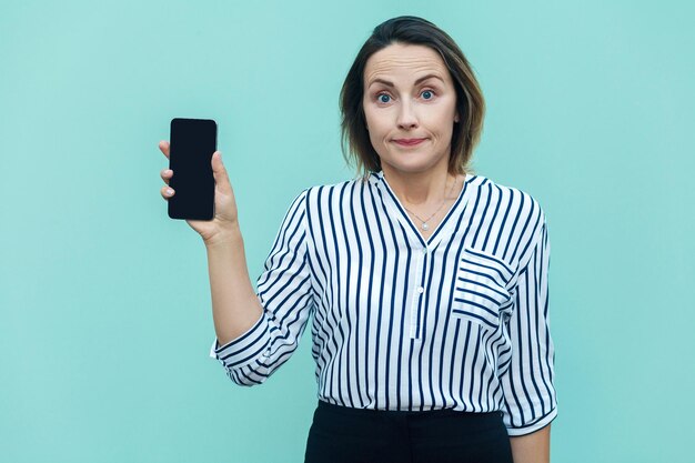 Succes zakenvrouw die nieuwe slimme telefoon toont en camera bekijkt