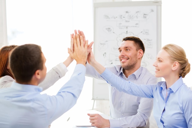 Photo success, business, office and winning concept - happy business team giving high five in office