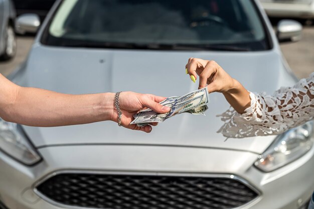 Успешная сделка по покупке автомобиля мужчина дает доллару продавцу купить автомобиль