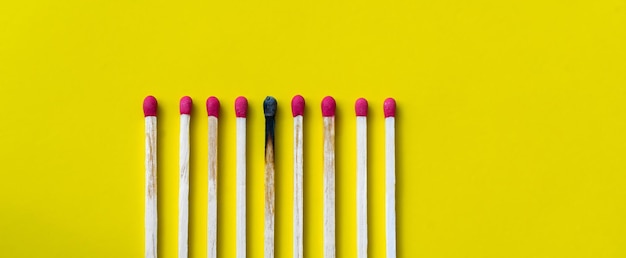 Success defeat achievement The concept of happiness Matches on a yellow background Burnt dark match among normal matches Burning match fire to its neighbors a metaphor for ideas and inspiration