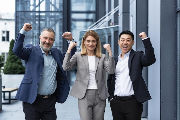 Gli uomini d'affari del gruppo felice di successo sono entusiasti di gioire guardando la fotocamera dopo il completamento con successo