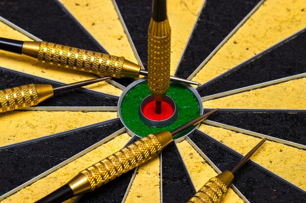 Success hitting target aim goal achievement concept background - darts in bull's eye close up