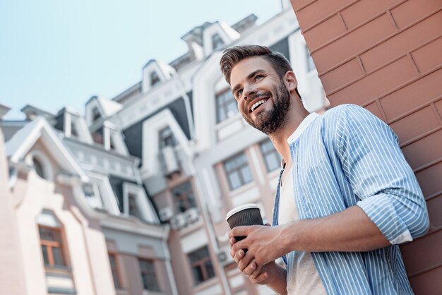 Success is peace of mind portrait of confident brownhaired man holding coffee cup and smiling