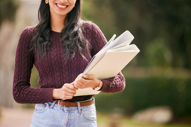 成功はあなたを待っています大学で彼女の教科書を外に持っている若い女性のショット