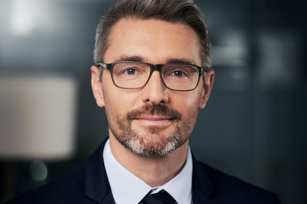 Photo success isnt something you get you earn it portrait of a mature businessman standing in his office