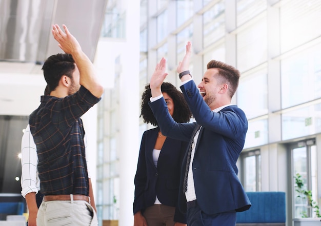 Foto ufficio di successo e uomini d'affari entusiasti danno il cinque dopo un buon incontro di affari e partnership collaborazione e diversità nel lavoro di squadra sul posto di lavoro aziendale con lavoratori felici in festa