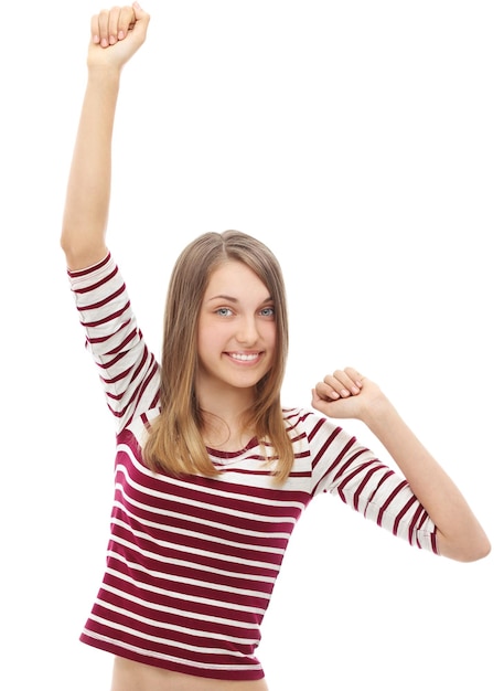Портрет успешной девушки, поднимающей руки и смеющейся перед камерой.