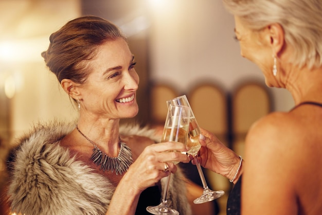Успешные женщины или тосты на вечеринке за голы или новый год на роскошном светском мероприятии Зрелый праздник или счастливые старшие друзья приветствуют шампанским или бокалами вина на веселом гала-ужине