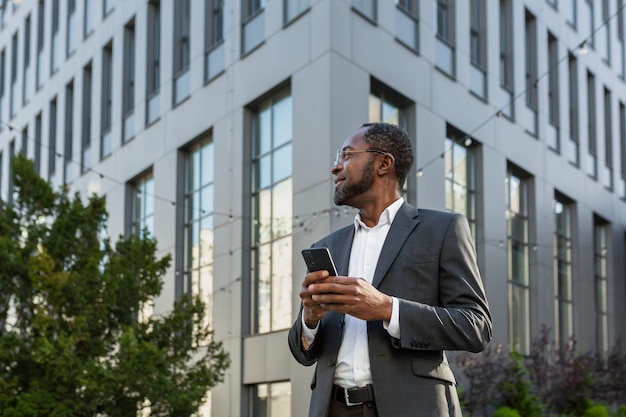 Successful african american boss businessman uses a telephone man types messages and browses