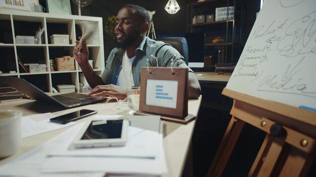 Successful african business man enjoying pile of money in modern coworking