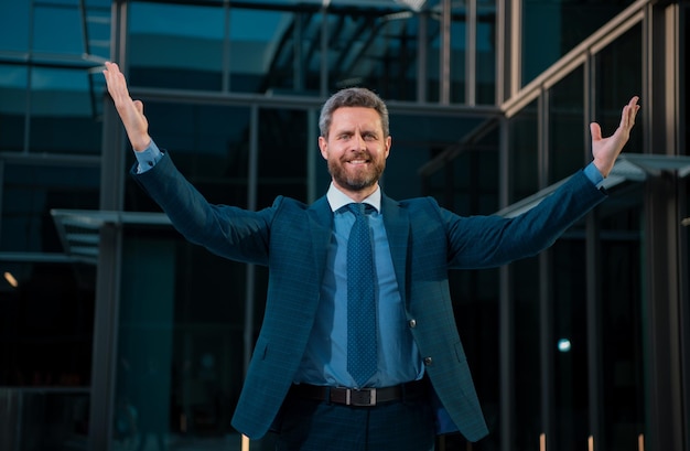 Photo successful amazed businessman near office buildings business man excited portrait