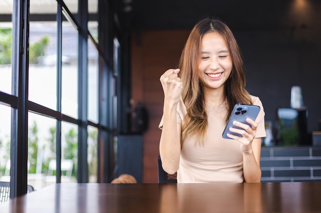 Successful Asian woman entrepreneurs using mobile smartphone in cafe for their businesses People working with technology and modern devices concept