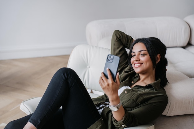 Successful attractive young African American woman sitting in cozy chair at home making video call