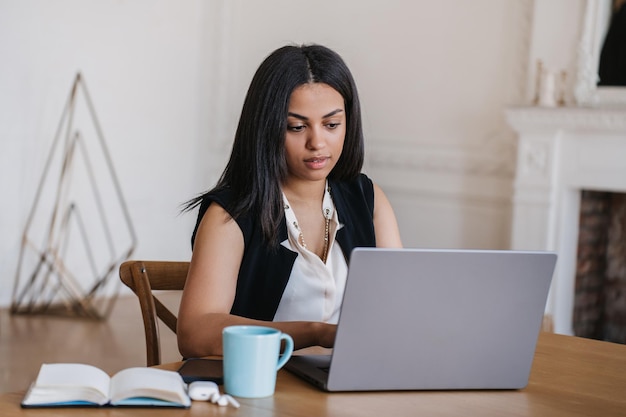 Successful attractive young African American woman sitting in cozy chair at home making video call