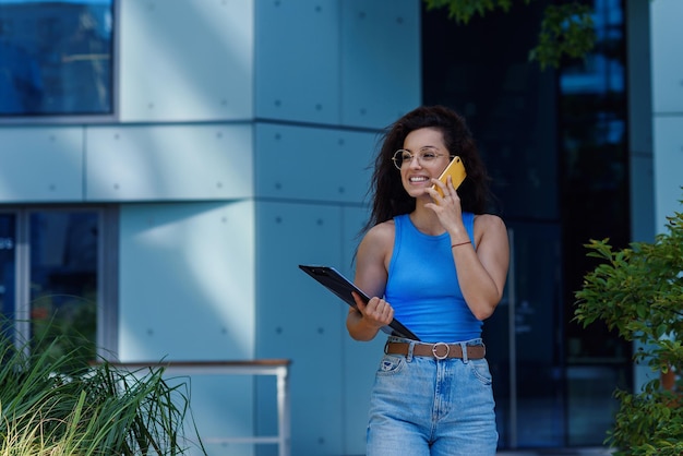 Successful beautiful business woman in suit with document walking to the meeting near modern office