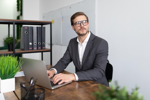 Successful broker sits in the office at work with a laptop