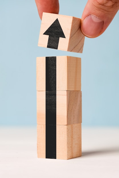 Successful business concept - abstract black arrow on wooden cubes.