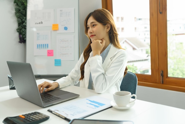 Успешная бизнес-концепция Деловая женщина вдумчивая и читает финансовый отчет на ноутбуке в офисе