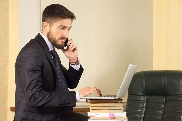 Successful business man in office working with laptop
