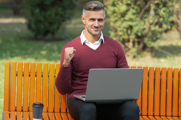 Successful business man working on computer with morning coffee outdoor success